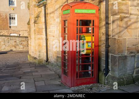 A vintage red telephone box at Palace Green, Durham, UK, converted to house a defibrillator. Stock Photo