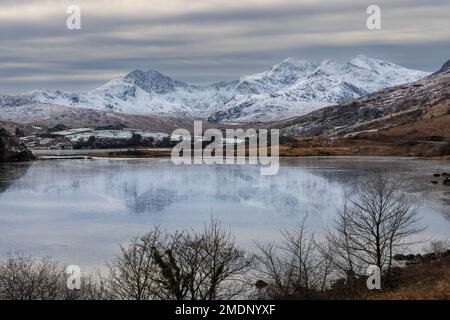 On a freezing, snowy day, Lliwedd, yr Wyddfa (Snowdon) and Crib Goch seen across Llyn Mymbyr in the foreground Stock Photo