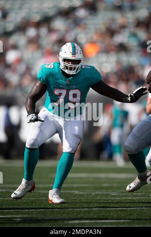 Miami Dolphins quarterback Skylar Thompson (19) calls a play in the huddle  with Miami Dolphins running back Sony Michel (28) and Miami Dolphins tackle  Larnel Coleman (79) during an NFL football game