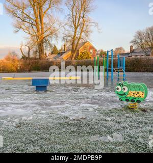 Fordingbridge, Hampshire, England, UK, 23rd January 2023, Weather: As the overflowing River Avon retreats, several hard frosts have covered the riverside playground and park in thick ice. Credit: Paul Biggins/Alamy Live News Stock Photo