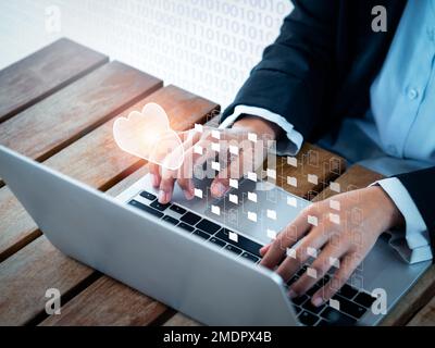 Cloud technology concept. Cloud icons with folders and document files showing on screen while businessperson working with laptop computer. Data storag Stock Photo