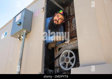 Bryan Anderson, a heating, ventilation, and air conditioning (HVAC) technician with Facilities Maintenance Branch, Public Works Division (PWD), Marine Corps Air Ground Combat Center (MCAGCC), operates on an air conditioning unit at MCGACC, Twentynine Palms, California, July 22, 2022. Despite the extreme heat of the high desert, the PWD, HVAC section maintains performance of air-cooling systems on buildings at the Combat Center. Stock Photo