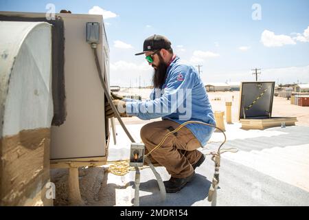 Bryan Anderson, a heating, ventilation, and air conditioning (HVAC) technician with Facilities Maintenance Branch, Public Works Division (PWD), Marine Corps Air Ground Combat Center (MCAGCC), operates on an air conditioning unit at MCGACC, Twentynine Palms, California, July 22, 2022. Despite the extreme heat of the high desert, the PWD, HVAC section maintains performance of air-cooling systems on buildings at the Combat Center. Stock Photo