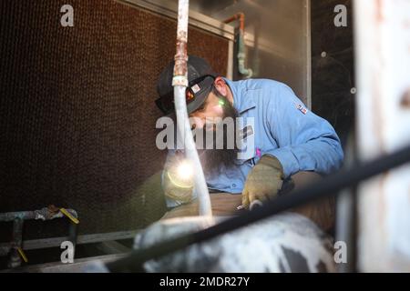 Bryan Anderson, a heating, ventilation, and air conditioning (HVAC) technician with Facilities Maintenance Branch, Public Works Division (PWD), Marine Corps Air Ground Combat Center (MCAGCC), operates on an air conditioning unit at MCGACC, Twentynine Palms, California, July 22, 2022. Despite the extreme heat of the high desert, the PWD, HVAC section maintains performance of air-cooling systems on buildings at the Combat Center. Stock Photo