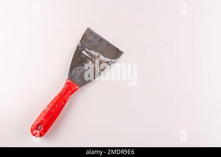 Selective focus top view of steel trowel scraper or construction spatula isolated on white background. Stock Photo