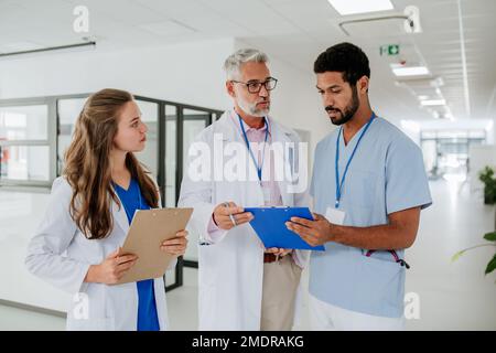 Medical staff discussing something at hospital corridor. Stock Photo