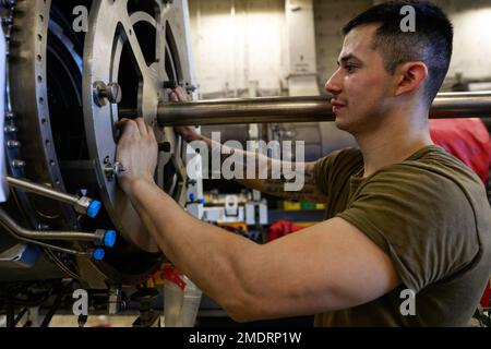 220726-N-CH260-1030 PACIFIC OCEAN (July 26, 2022) Airman Carlos Bermudez, from Maryland, Va., installs a combustor on a jet engine in the jet shop of the Nimitz-class aircraft carrier USS Abraham Lincoln (CVN 72). The Abraham Lincoln Carrier Strike Group is underway conducting routine operations in the U.S. 3rd Fleet. Stock Photo