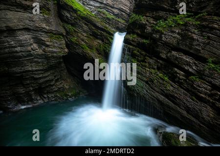 A mystical waterfall surrounded by moss Stock Photo