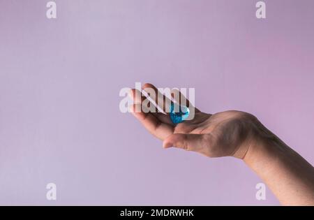 Blue glass heart in woman hand. Love concept on Valentine day. Stock Photo