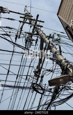 Chaotic web of electric wires in Fukuoka city, Japan. Asian mess of electric cables Stock Photo