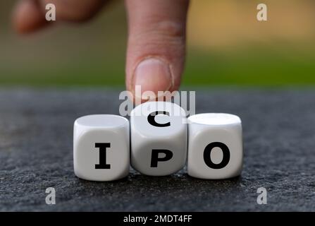 Hand turns dice and changes the abbreviation IPO (initial public offering) to ICO (initial coin offering). Stock Photo