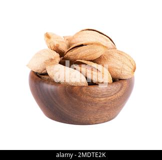 Mountain almonds in wooden bowl, isolated on white background. Uzbek wild almonds Stock Photo