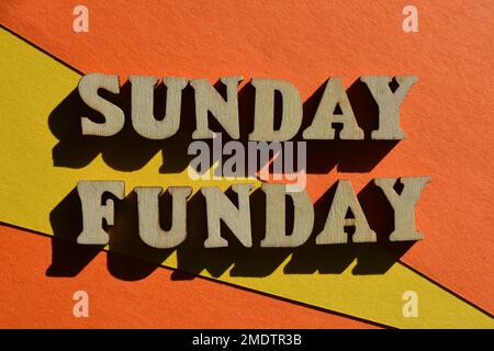 Sunday Funday, words in wooden alphabet letter shapes isolated on bright yellow and orange background Stock Photo