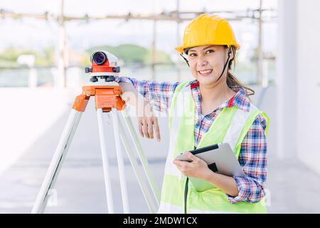 woman worker engineer with digital tablet survey equipment auto levelling camera happy smile Stock Photo
