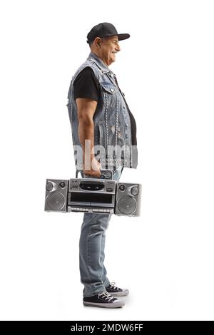 Full length profile shot of a mature man with a cap standing and holding a boombox radio isolated on white background Stock Photo