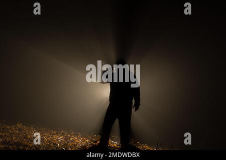 Suicide armed silhoulette man in dark forest at backlight Stock Photo