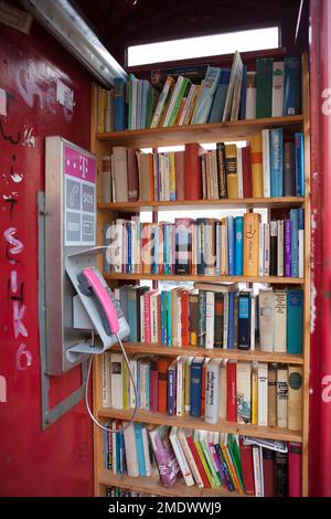 British red telephone box used as a book exchange, Hachenburg, Westerwaldkreis in Rhineland-Palatinate, Germany Stock Photo