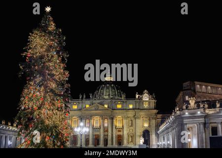 Rome, Italy - December 31, 2022: St. Peter's basilica decorated with Christmas lights and tree. Night scene. Stock Photo