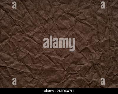 Dark brown crumpled paper texture. Blank page pattern for winter season Christmas festival card, new year designs decoration, background concepts Stock Photo
