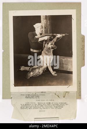 Coast Guard Dog Patrol. This image depicts a Coast Guardsman as he trains his sub-machine gun on the spot where a suspicious sound came from, challenging the intruder. Stock Photo