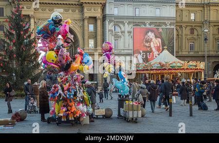 Christmas tree, carousel and balloons for sale at Piazza della Repubblica in winter, in Florence, Tuscany, Italy. Stock Photo