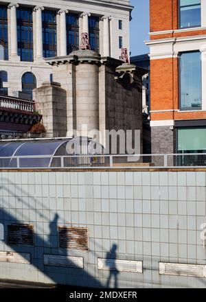 22 Jan 2023 - LondonUK: Shadow of people walking down steps on tiled wall on sunny day in city Stock Photo