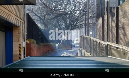 22 Jan 2023 - LondonUK:sunbeams through light fog on sunny day in urban city block Stock Photo