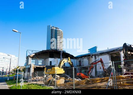 Demolition of the old building with sloopkraan against blue clouds sky. Stock Photo