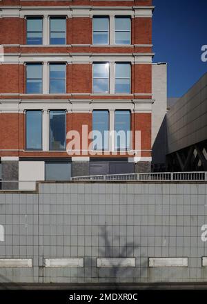 Modern building with red brick above an old tiled wall Stock Photo