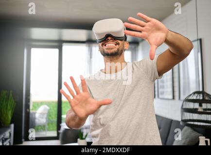 Technology, virtual reality and hands of man in home with headset for streaming interactive, online and 3d games. Futuristic, digital tech and guy Stock Photo