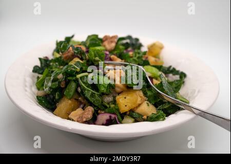 Delicious green Tuscan kale salad on white background.  Stock Photo