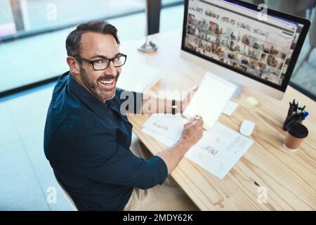 This is what Im working on right now. a mature businessman using his digital tablet while sitting at his desk. Stock Photo