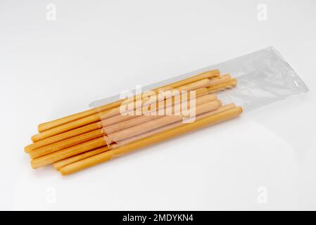 Breadsticks come out of transparent packaging. typical Italian Bread sticks isolated on whiye Stock Photo