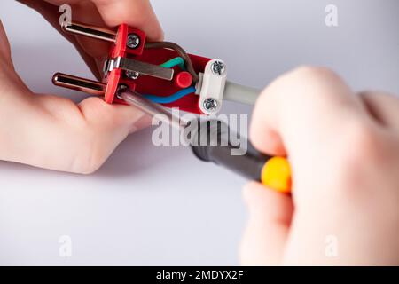 electrician disassembles electric plug. Electric plug with outlet isolated on white background. European electric plug assembly. dismantled electric p Stock Photo