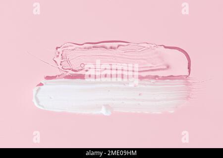 White cream and clear gel cosmetic smudge drops texture isolated on pink background. Cosmetic smears