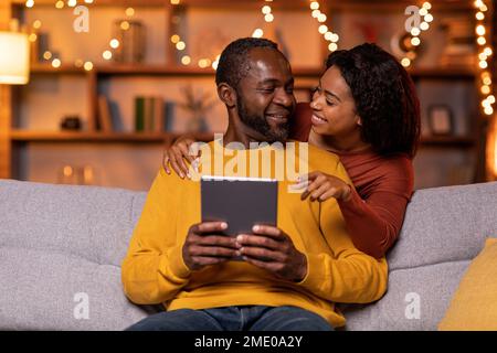 Married black couple using digital tablet at cozy winter evening Stock Photo