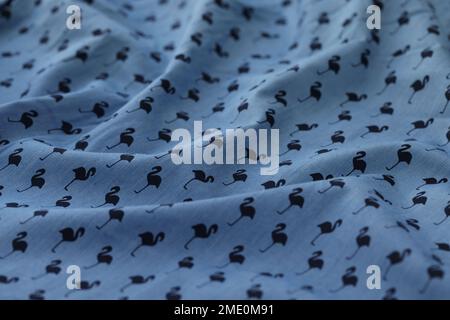 Wavy blue fabric with flamingo picture. Stock Photo