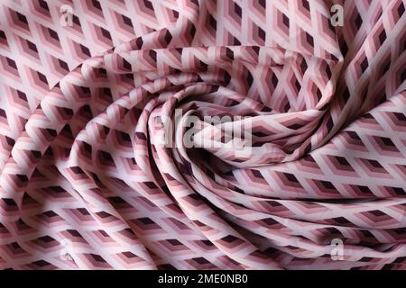 Swirled pink and white fabric with geometric ornament as background. Stock Photo