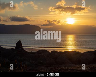Contemplation as the sunsets over the Irish Sea at Llandudno, North Wales. Stock Photo