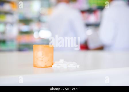 Meds to treat mild to moderate pain. a container filed with medication on a counter in a pharmacy. Stock Photo