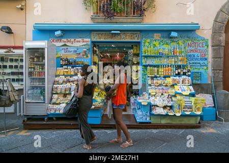 Two dark-skinned young women walking past a souvenir shop in Sorrento, Campania, Italy. Stock Photo