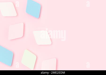 Multicolored makeup sponges scattered on a pink pastel background. Place for text. Stock Photo