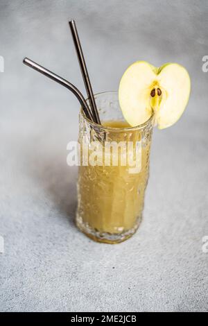 Fresh apple smoothie served in glass with sliced apple on concrete background Stock Photo