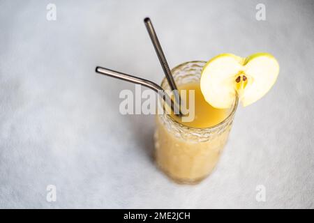 From above fresh apple smoothie served in glass with sliced apple on concrete background Stock Photo