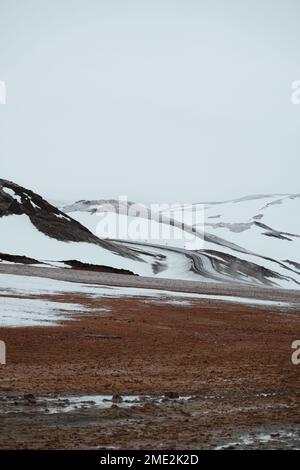 Frozen valley and snowy hills located against dull sky on cold winter day in countryside of Iceland Stock Photo