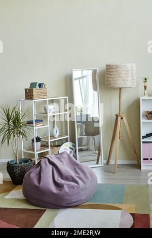Vertical background image of playful home interior in pastel muted colors with comfy bean bag and floor mirror Stock Photo