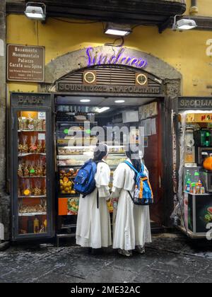 Two nuns dressed in white robes and black habits standing outside of Sinduco gelateria in Naples, Italy. Stock Photo