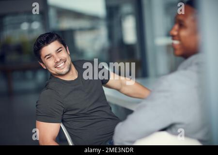 We prefer our meetings to be relaxed. two young businessmen having a meeting in a modern office. Stock Photo