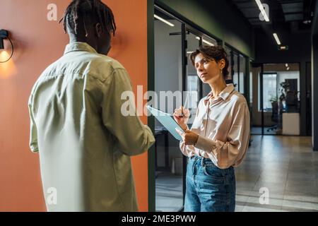 Businesswoman having discussing with young businessman Stock Photo