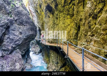 Austria, Boardwalk stretching through Leutasch Gorge with female hiker standing in background Stock Photo